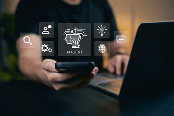 Person Using Smartphone to Interact with AI Agent Features and Technology Icons on Laptop Display in Modern Office Environment