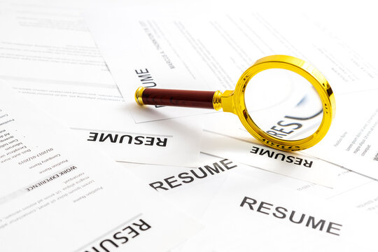 Resume papers and tools for review, representing human resources, job application process, and applicant evaluation