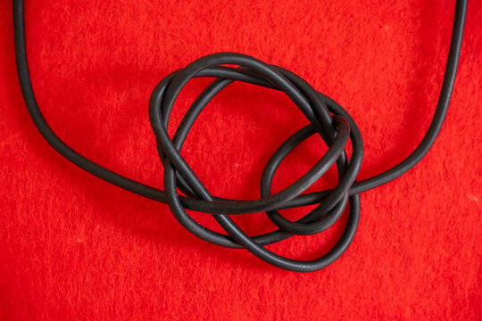 Tangled Cable on Red Background Representing Confusion and Problem, Abstract Technology Concept with Wire and Connection