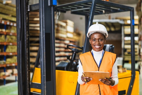 Female worker managing inventory in lumberyard warehouse