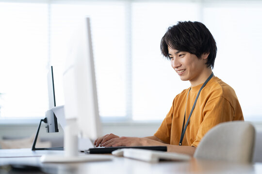 オフィスでパソコンを使って仕事をする若い男性エンジニア