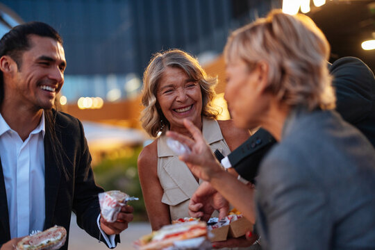 Friends eating street food outdoors at night