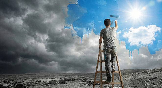 Man Painting Dark Gray Sky Blue Revealing Sun and Bright Future