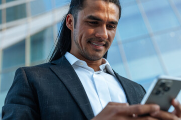 Fototapeta premium Businessman networking on smartphone in urban city