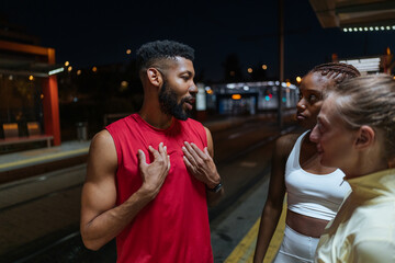 Diverse group friends talking after night workout