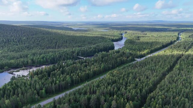 High aerial drone of E75 highway traffic and Kitinen River Lapland