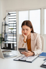 Fototapeta premium Asian businesswoman working with financial documents in office having problems with taxes and accounting.
