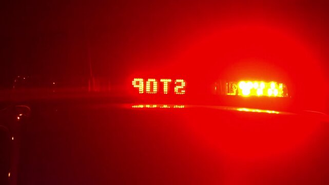 Police patrol car with flashing red and white emergency lights at night. Visible "Police" text on lightbar. Cinematic law enforcement response and public safety concept.
