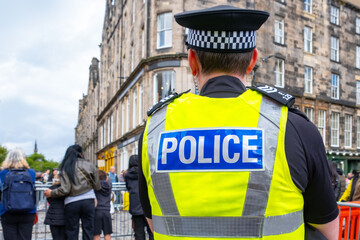 City police officer in uniform walking on city street, ensuring public safety, uniformed policeman...