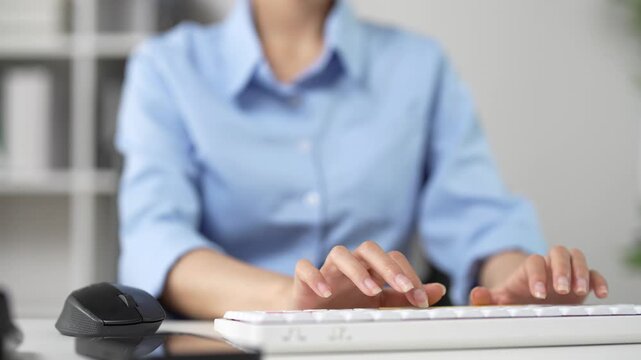Professional woman hands typing on a white computer keyboard, business entrepreneur working on a desktop, programmer coding and browsing the internet in an office environment