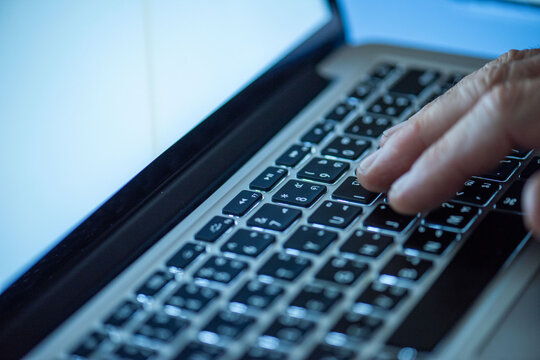 Hand typing on laptop keyboard.