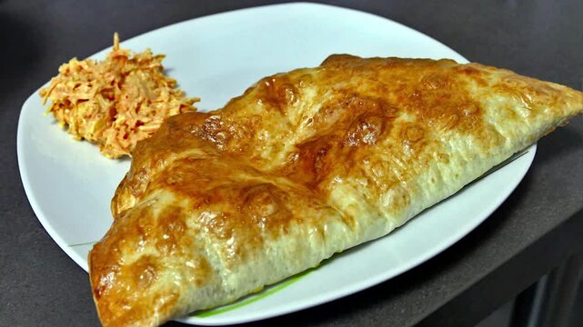 A fried cheburek on a plate.