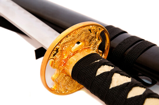 Japanese katana sword close up, golden tsuba and traditional samurai weapon isolated on white background