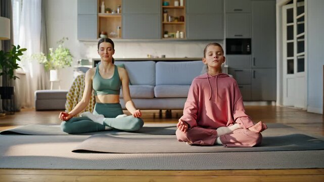 Mom daughter yogini meditating yoga mat. Sport family sitting with closed eyes