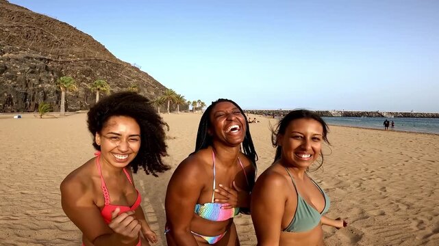 Young multiracial women having fun dancing on the beach during summer vacation - Travel and holidays concept -UGC content