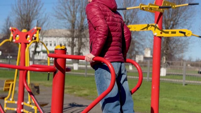 Man doing triceps dips on outdoor parallel bars at public gym