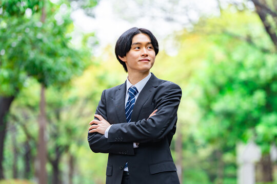 腕組みをするスーツを着た若手男性