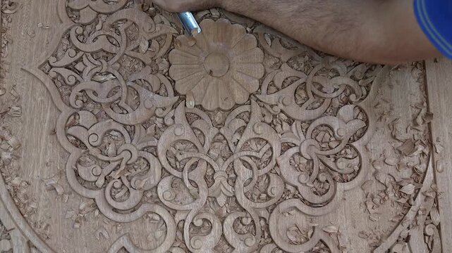 Close-up footage of a skilled artisan carving intricate patterns on wood. Showcasing traditional craftsmanship, fine details, and natural textures in a mesmerizing handmade process.