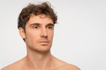 Fototapeta premium Beauty, serious and portrait of man in studio for antiaging treatment or dermatology. Topless, cosmetics and skincare with model isolated on white background for self care, copy space