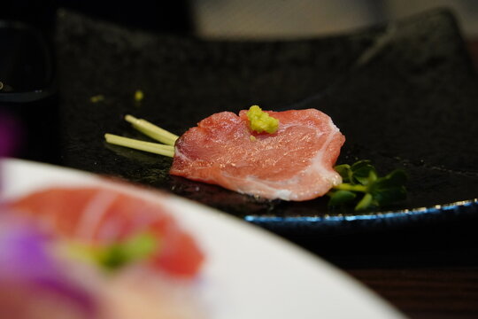 Close up of marbled bluefin tuna otoro sashimi garnished with radish sprouts