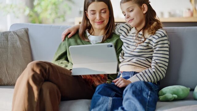 Resting relatives browsing tablet chilling sofa closeup. Sisters watching video