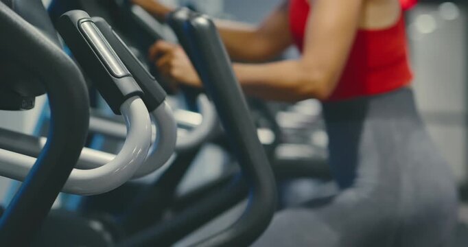 Woman Exercising on Elliptical in Modern Gym