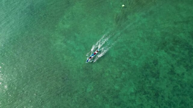 Aerial view of boat moving on clear green ocean water