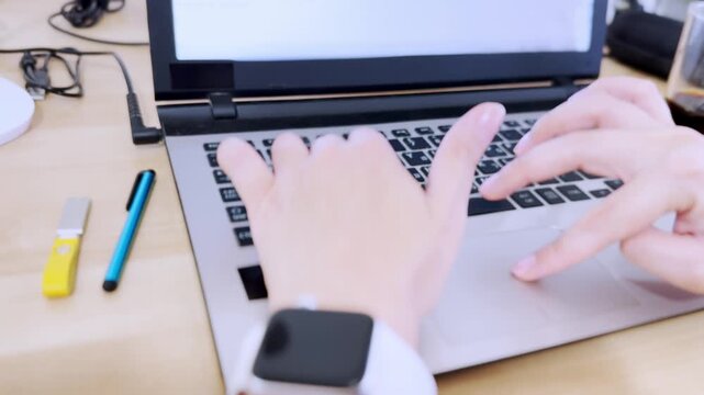 Close-up front view of hands actively typing on a laptop keyboard with Hebrew and English characters