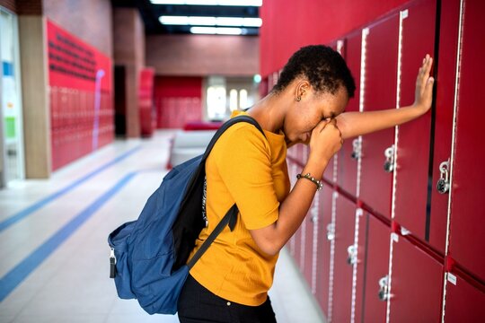 Stressed student leaning lockers photo