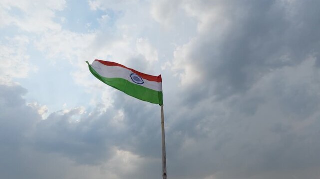 Indian flag waving in the wind against cloudy sky slow motion horizontal video footage.