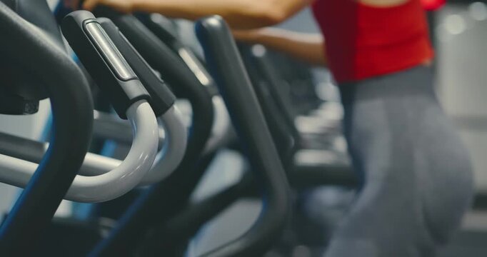 Woman Exercising on Elliptical in Modern Gym