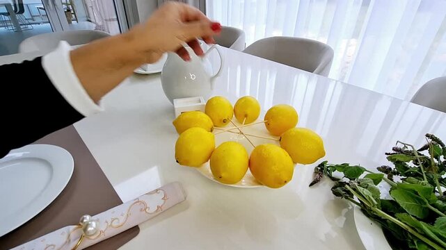 Hand stacking fresh yellow lemons into a pyramid shape