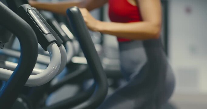 Woman Exercising on Elliptical in Modern Gym