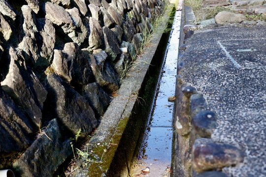 用水路と石垣・苔むした古い水路・田舎の農業用水