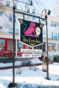 Stockbridge, MA - USA: Sign for the historic Red Lion Inn with inn and snow in background. Diagonal angle of vew.