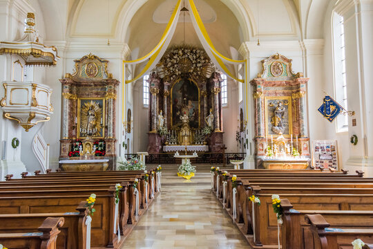 Interior of St. Andreas church in Etting with ornate baroque altar, pulpit and wooden pews
