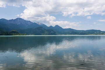 Obraz premium Panoramic view of lake Kochelsee with mountain reflections and Herzogstand peak in the Bavarian Alps