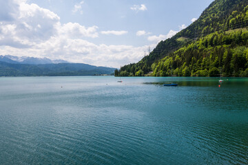 Obraz premium Panoramic view of turquoise Lake Walchensee and the Bavarian Alps under a cloudy sky