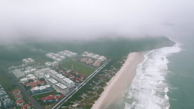 Misty aerial over Ingleses neighborhood and beach shoreline