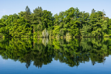 Fototapeta premium Wooden pier overlooking the calm water of Wesslinger See lake in Bavaria, Germany