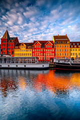 Obraz premium Vertical photo traditional colorful buildings of Nyhavn in Copenhagen at sunrise with boats, Denmark
