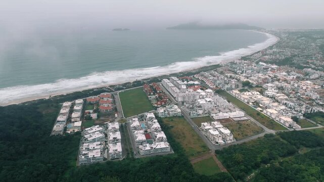 Aerial over Ingleses beachfront district and curved shoreline