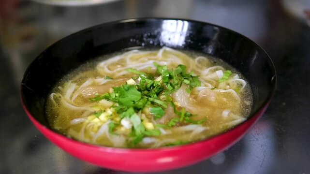 Delicious bowl of fresh pho with herbs served in Hanoi, Vietnam, a must-try local specialty for food lovers