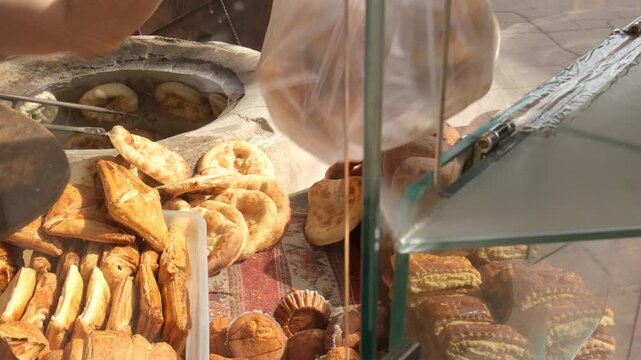 Selling fresh bread through bakery window. Customer pays banknote to baker and receives package with bread. Neighborhood bakery with always fresh crispy bread. Grain abundance and no shortage of wheat
