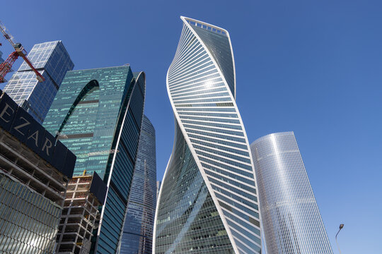 Evolution Tower and skyscrapers of Moscow City business district against clear blue sky, bottom view