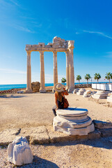 Obraz premium Female tourist looking at the Temple of Apollo by the sea in Side, Turkey