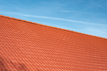 Fototapeta premium Red clay tile roof against clear blue sky