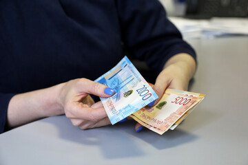 Russian rubles in female hands, cash pay, salary, inflation or savings concept. Woman counting money in office