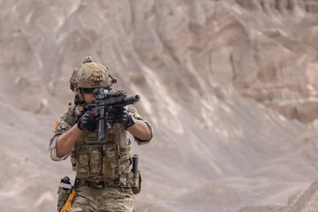 Obraz premium soldier in desert landscape with weapon ready during military operation