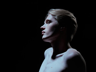 Side profile of young man with strong jawline and soft highlighted skin. Concept of premium skincare branding, luxury cosmetic advertising, beauty campaign and product positioning.